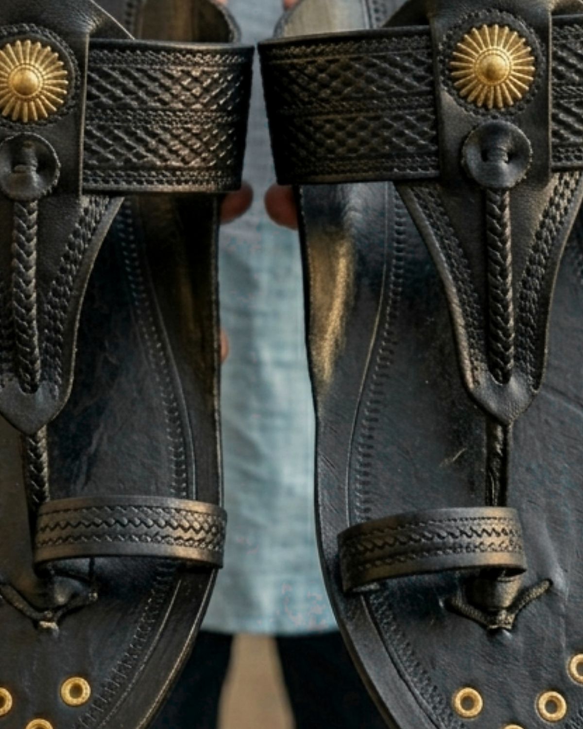 Detail of the black strap and hand-set brass button
