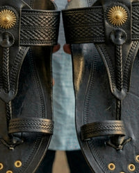 Detail of the black strap and hand-set brass button