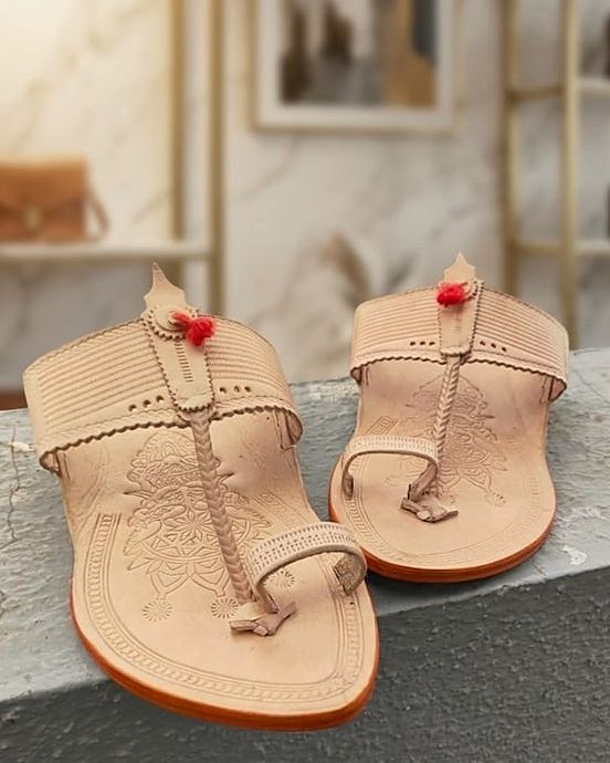 Rajmudra in natural leather with a red tassel, pair on a stone ledge