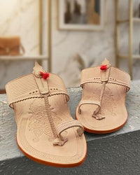 Rajmudra in natural leather with a red tassel, pair on a stone ledge